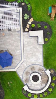 an aerial view of a backyard with a patio, umbrella and picnic table in the background