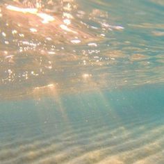 the sun shines through the water as it reflects on the sandy beach bottom surface