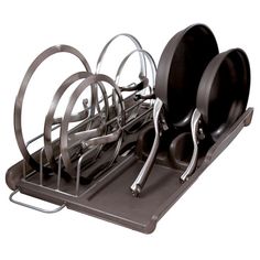 a metal dish rack with black plates and silver utensils