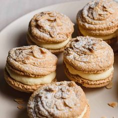 several cookies and pastries on a plate with powdered sugar toppings in the middle