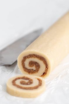 there is a roll with cinnamon on the wrapper next to it and a knife