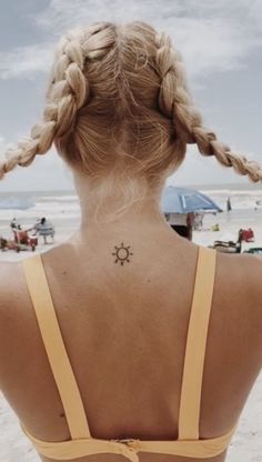 a woman with a sun tattoo on her back