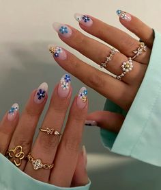 a woman's hand with many different rings on her fingers and two other hands