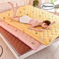 a woman laying on top of three mattresses