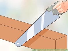 a person using a saw to cut a piece of wood with a box underneath it