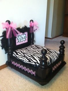 a zebra print bed with pink bows on the headboard and foot board is shown