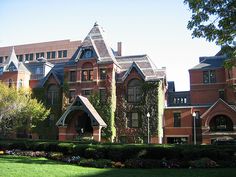 an old building with ivy growing on it's sides and two large windows in the front