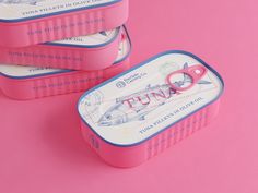 three pink tins with scissors in them sitting on a pink surface, next to each other