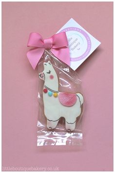 a packaged cookie shaped like a llama with a pink bow