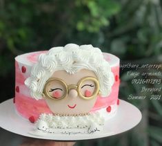 a cake with a woman's face and glasses on it, sitting on a plate