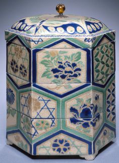 a decorative box with blue and green designs on it's sides, in the shape of hexagonal tiles