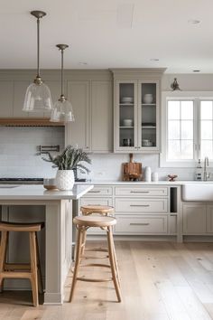 a kitchen with two stools in front of the island and cabinets on both sides