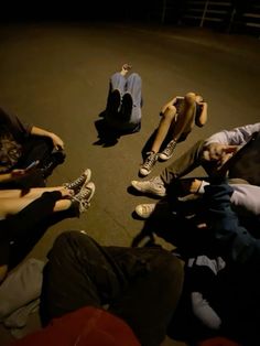 four people sitting on the ground with their feet up