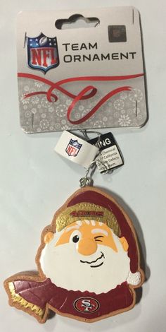 the nfl christmas ornament has a santa clause on it's head and is next to a card