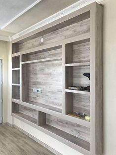 an empty room with wooden shelves on the wall and wood flooring in front of it