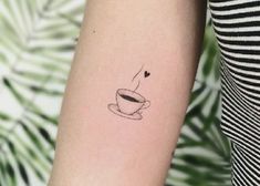 a woman's arm with a coffee cup and heart tattoo on the left forearm