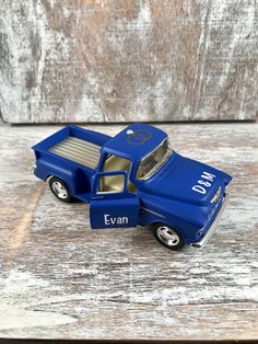 a blue toy truck sitting on top of a wooden table