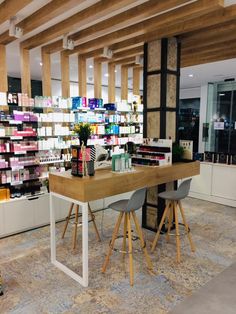 a table with two chairs in front of it and shelves full of bottles on the wall