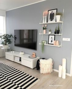 a living room filled with furniture and a flat screen tv on top of a wall