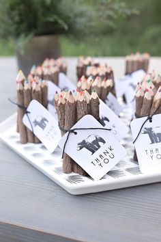 small wooden sticks with tags tied to them sitting on a plate