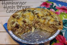 a casserole pie with meat and cheese on it sitting on top of a table