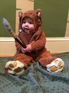 a baby in a bear costume holding a baseball bat