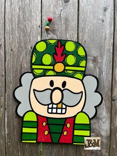 a wooden sign with a cartoon character painted on it's face and wearing a green hat