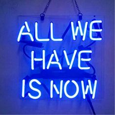 a neon sign that says all we have is now hanging on the side of a wall