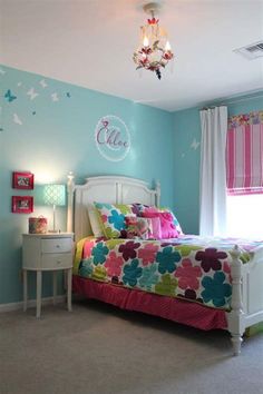 a bedroom with blue walls and colorful bedding