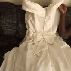 a woman in a white wedding dress laying on a couch with her hands behind her head