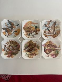 four plates with birds painted on them