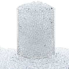 a clear glass filled with water on top of a white tablecloth covered in bubbles