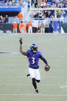 a football player is running with the ball in his hand and people are watching from the stands