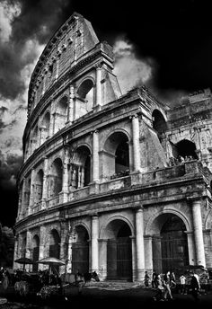 black and white photograph of the colossion in rome, italy with dramatic clouds