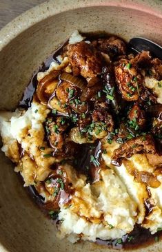 a bowl filled with mashed potatoes, meat and gravy