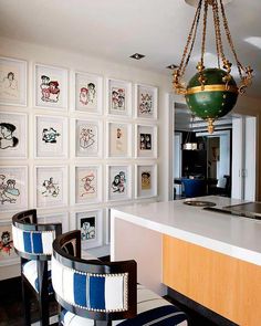 a kitchen with pictures on the wall and chandelier hanging from it's ceiling