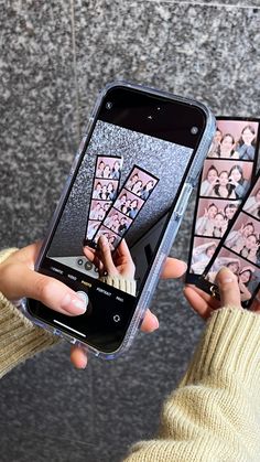 two people holding up cell phones with stickers on them and one person taking pictures