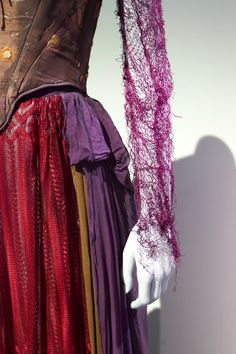 a woman's purple and red dress on display