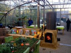 a living room filled with lots of furniture and plants in front of a fire place