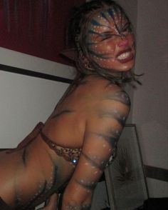 a woman with painted face and body poses for the camera