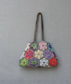 a handbag hanging on the wall with flowers painted on it's front and sides