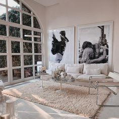 a living room filled with white furniture and large glass doors leading to an outside patio