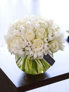 a vase filled with white flowers on top of a table