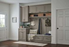 an entryway with gray cabinets and wooden floors