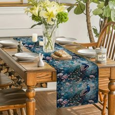 a dining room table set with place mats, plates and vases on the table