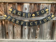 there is a sign that says aged to perfection one on it hanging from the side of a wooden fence