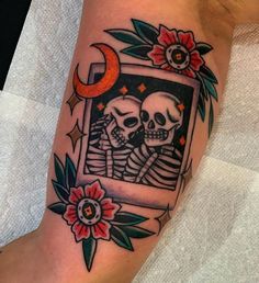 a couple of skulls sitting next to each other on top of a person's leg