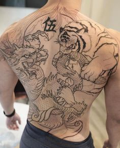 a man with a tiger and dragon tattoo on his back