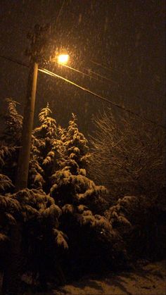 a street light in the snow at night