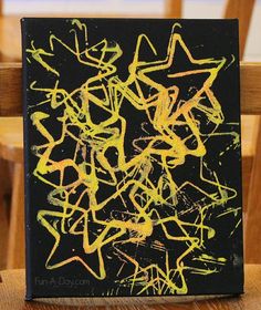 a black and yellow painting sitting on top of a wooden chair